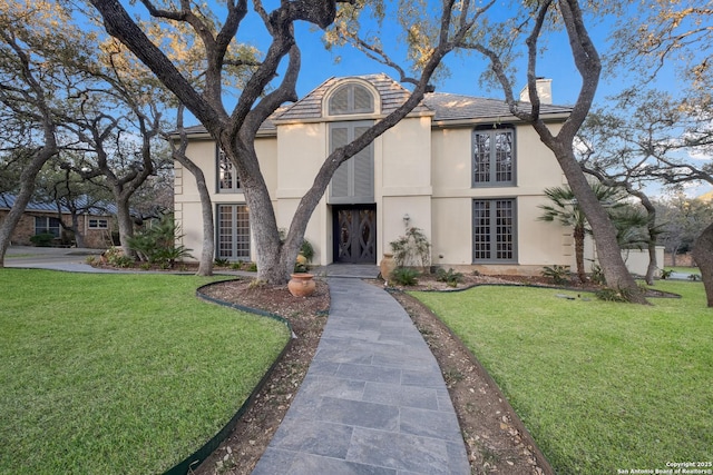 tudor-style house featuring a front yard