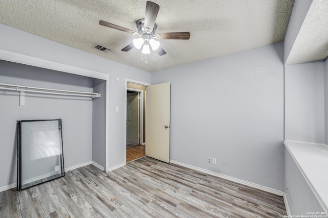 unfurnished bedroom featuring a closet, ceiling fan, a textured ceiling, and light hardwood / wood-style flooring