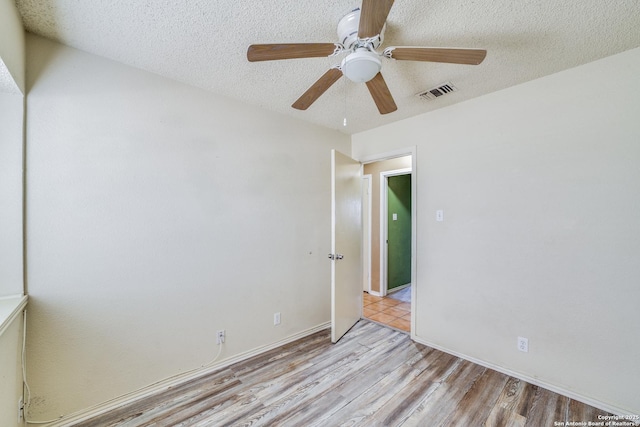 unfurnished bedroom with ceiling fan, light hardwood / wood-style floors, and a textured ceiling