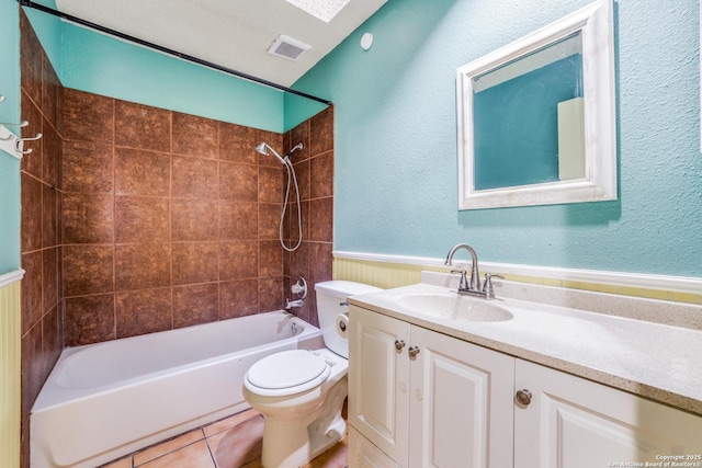 full bathroom featuring tiled shower / bath combo, vanity, a textured ceiling, tile patterned floors, and toilet