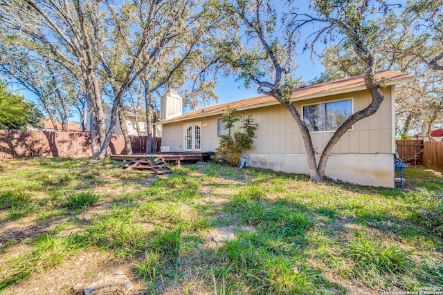 back of property featuring a lawn and french doors