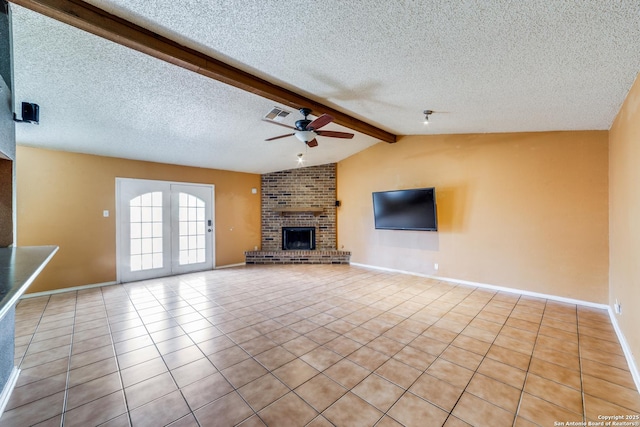 unfurnished living room featuring light tile patterned floors, ceiling fan, a fireplace, lofted ceiling with beams, and a textured ceiling