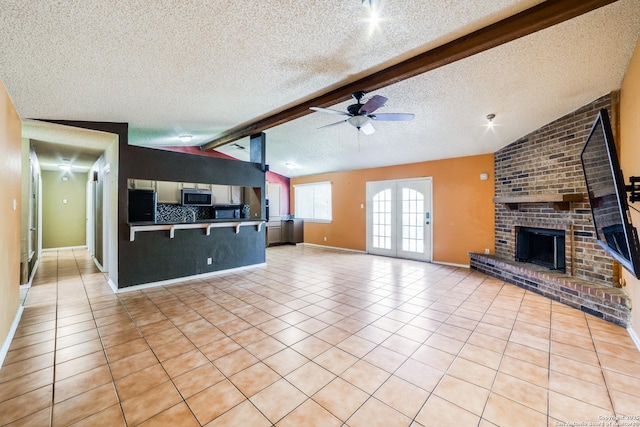 unfurnished living room featuring ceiling fan, vaulted ceiling with beams, light tile patterned floors, and a fireplace