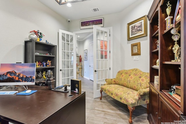 office featuring light hardwood / wood-style floors and french doors