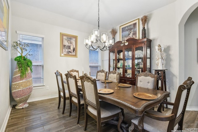 dining space with dark hardwood / wood-style flooring and a notable chandelier