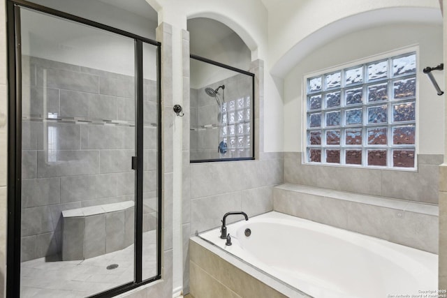 bathroom featuring plus walk in shower and a wealth of natural light