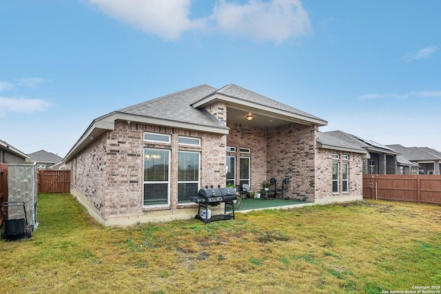 back of house with a yard and a patio