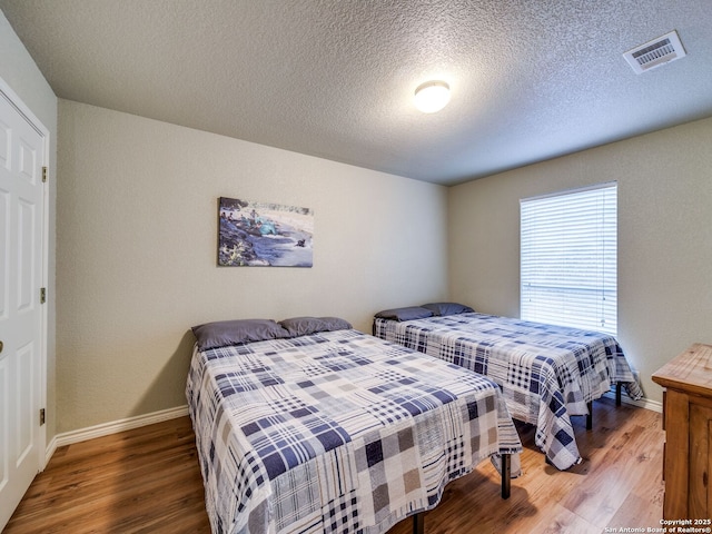 bedroom featuring wood-type flooring and a textured ceiling