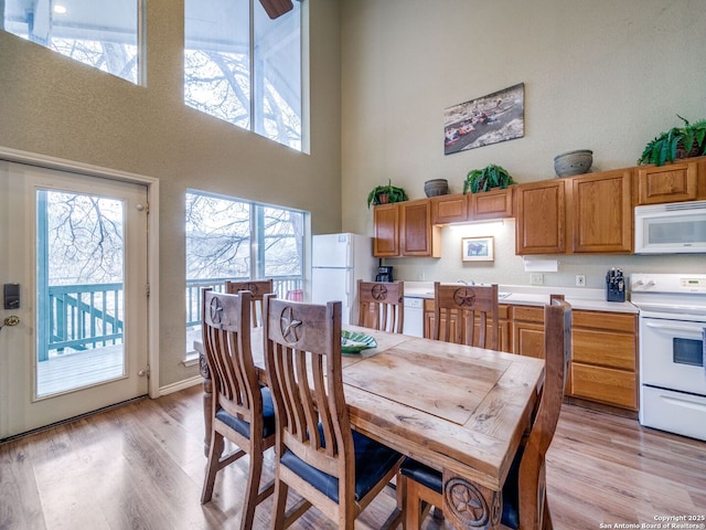 dining space with a high ceiling and light wood-type flooring