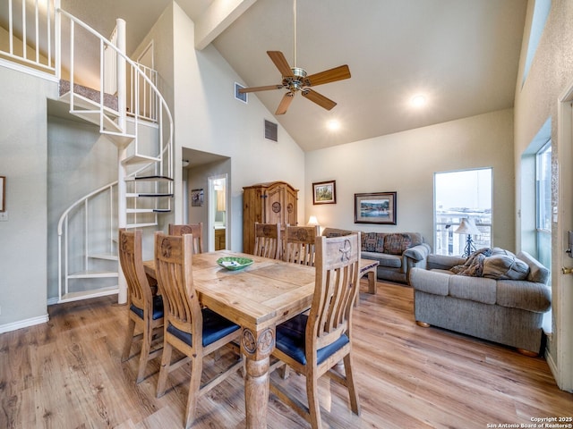 dining space featuring ceiling fan, high vaulted ceiling, and light wood-type flooring