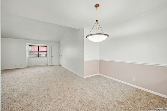 carpeted empty room with vaulted ceiling