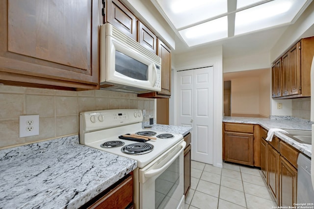 kitchen with white appliances, sink, decorative backsplash, and light tile patterned floors