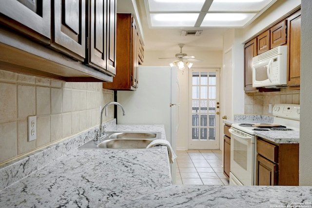 kitchen featuring sink, white appliances, light tile patterned floors, ceiling fan, and decorative backsplash