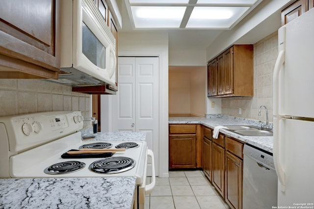 kitchen featuring white appliances, sink, decorative backsplash, and light tile patterned floors