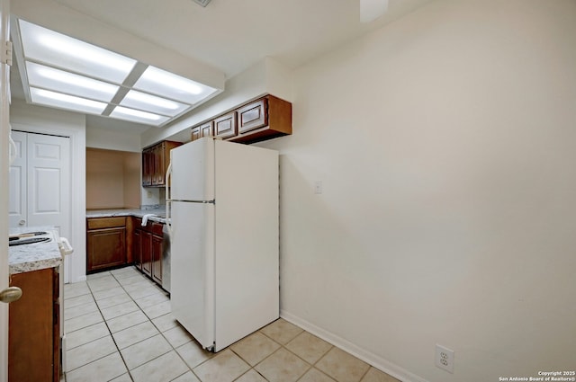 kitchen with white appliances and light tile patterned flooring