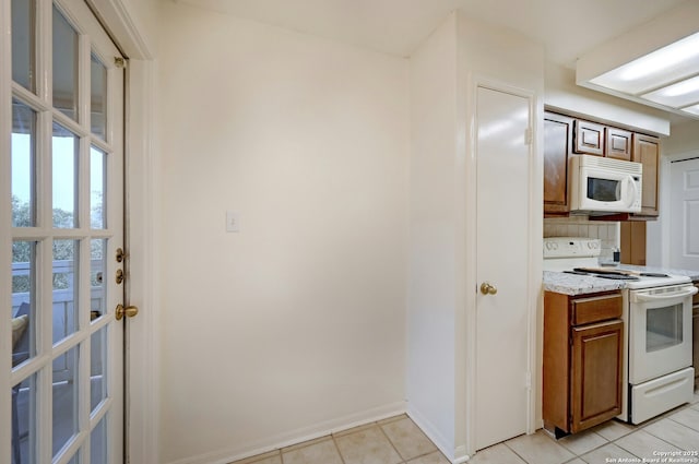 kitchen with light tile patterned floors and white appliances