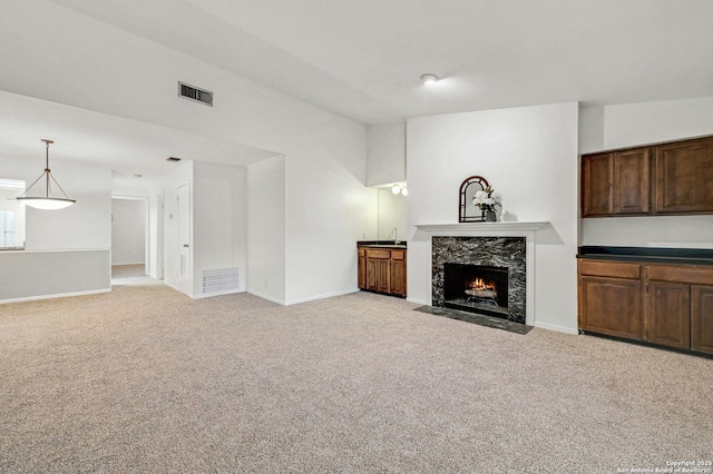 unfurnished living room featuring light carpet and a fireplace