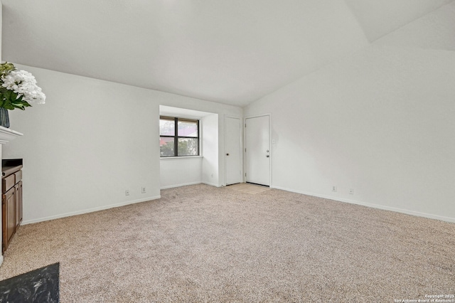 interior space featuring light colored carpet and vaulted ceiling