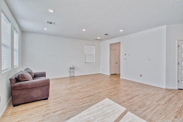 living area with a textured ceiling and light wood-type flooring