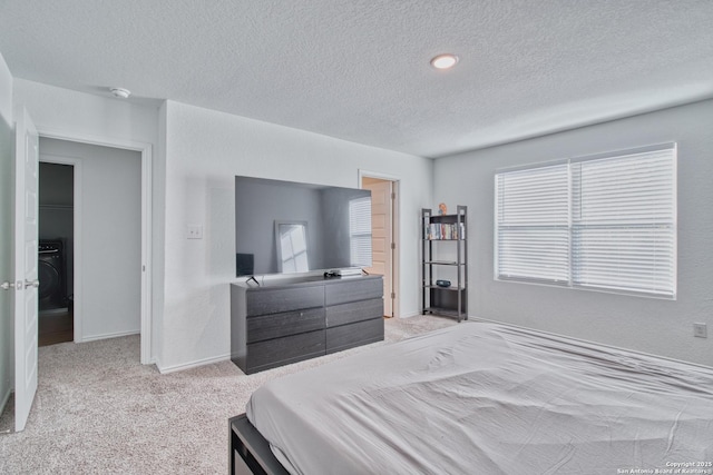 bedroom with multiple windows, light carpet, and a textured ceiling