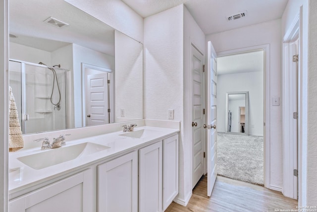 bathroom featuring vanity, hardwood / wood-style floors, and an enclosed shower