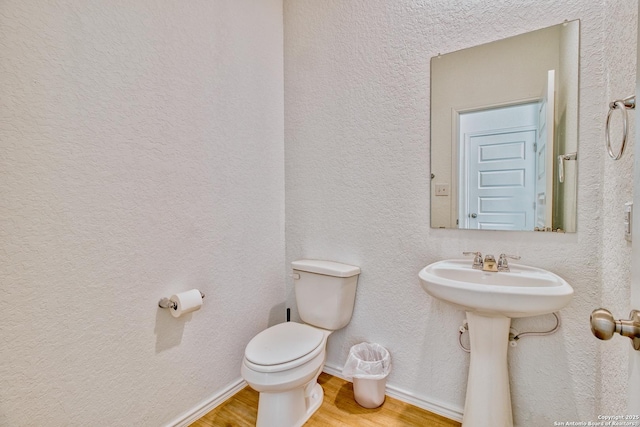 bathroom with hardwood / wood-style floors and toilet