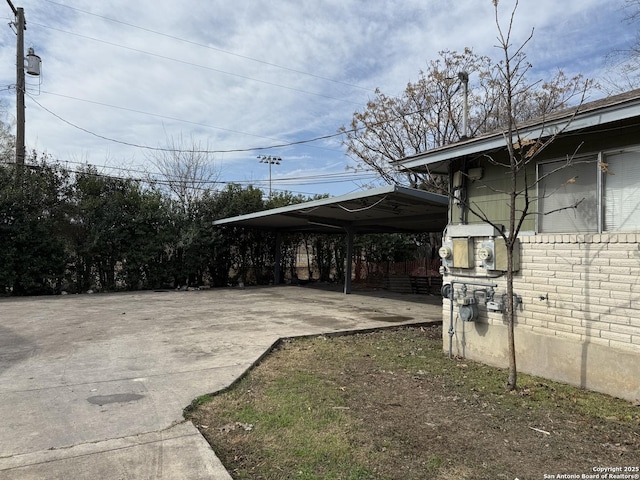 view of parking / parking lot with a carport and concrete driveway