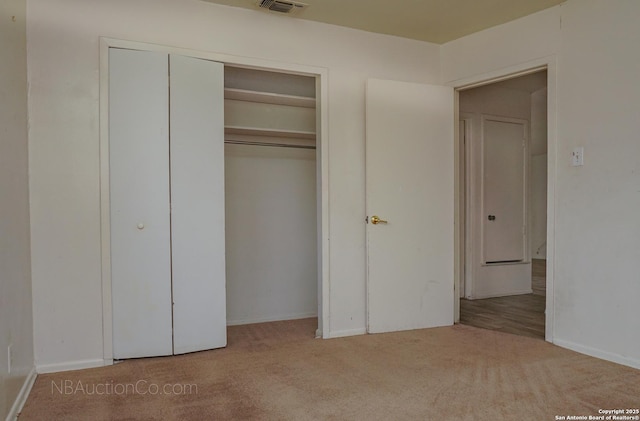 unfurnished bedroom featuring carpet floors, a closet, and visible vents