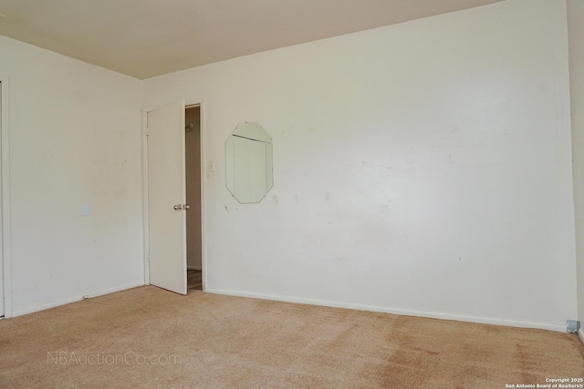 unfurnished room featuring baseboards and light colored carpet