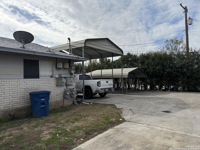 view of vehicle parking with concrete driveway and a detached carport