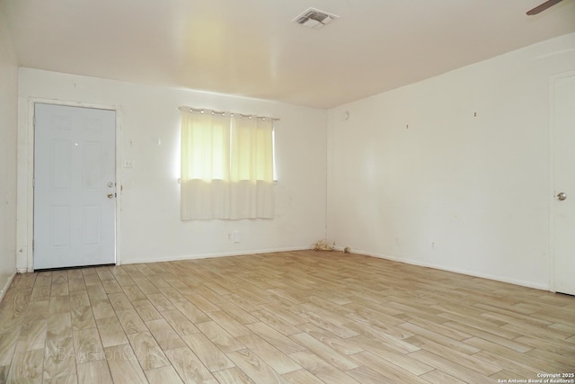 spare room with baseboards, visible vents, and light wood-style floors