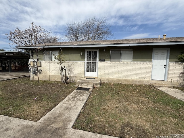 view of front of property with a front yard and a carport