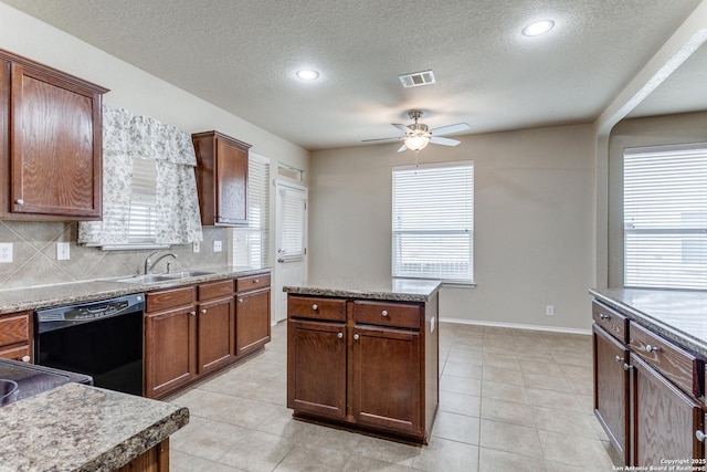 kitchen featuring a kitchen island, tasteful backsplash, black dishwasher, sink, and ceiling fan