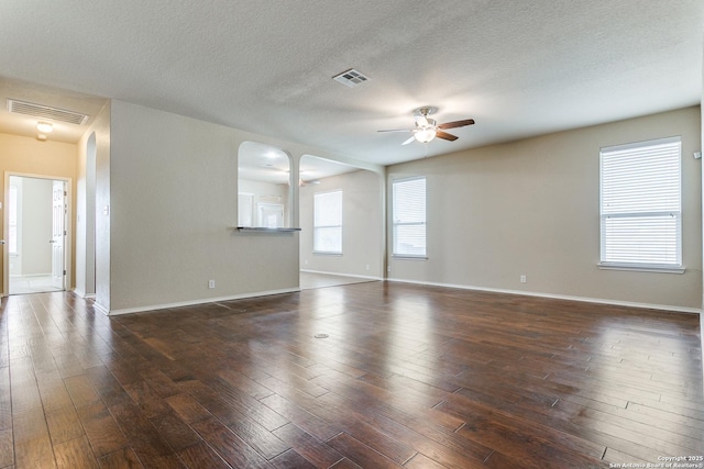 empty room featuring dark wood-type flooring, ceiling fan, and a textured ceiling