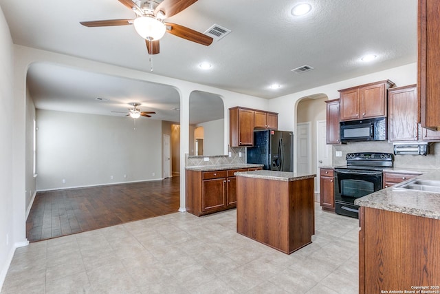 kitchen with ceiling fan, backsplash, a center island, black appliances, and kitchen peninsula