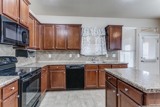 kitchen featuring light tile patterned flooring, sink, tasteful backsplash, a center island, and black appliances