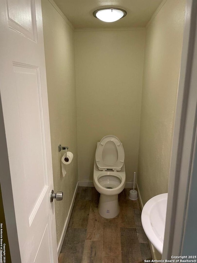 bathroom featuring wood-type flooring and toilet