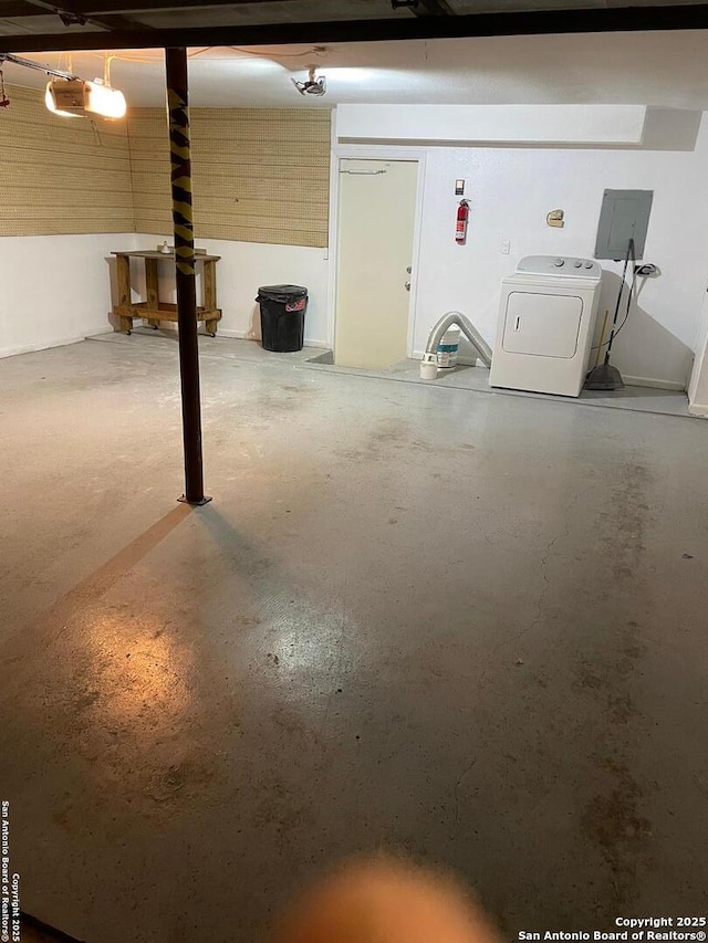 garage featuring a garage door opener, washer / dryer, and electric panel