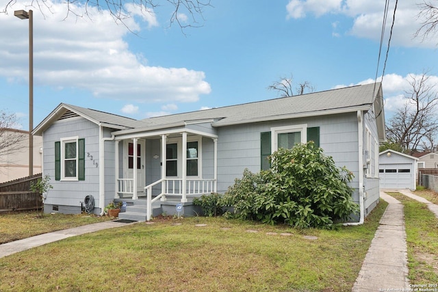 view of front of house featuring a garage, an outdoor structure, a front lawn, and a porch