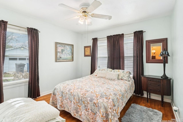 bedroom with multiple windows, ceiling fan, and dark hardwood / wood-style flooring