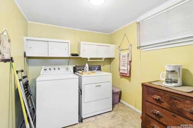 washroom with crown molding, cabinets, washer and dryer, and light tile patterned floors