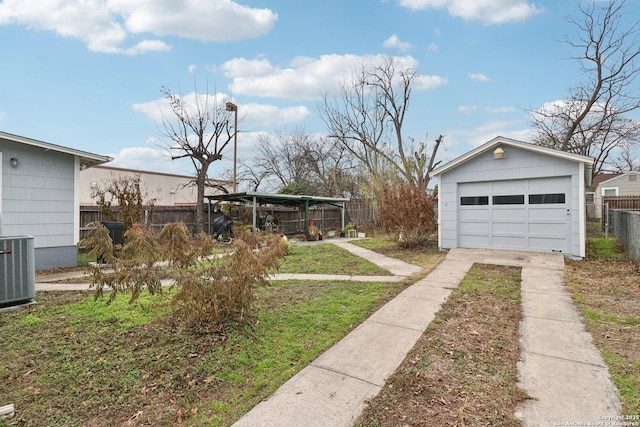 view of yard featuring a carport, a garage, an outbuilding, and central air condition unit