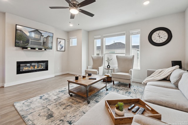 living room with light hardwood / wood-style flooring and ceiling fan