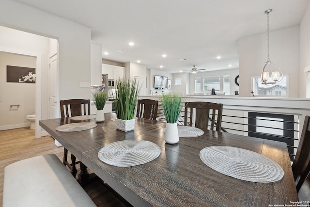 dining area with light hardwood / wood-style flooring and a notable chandelier