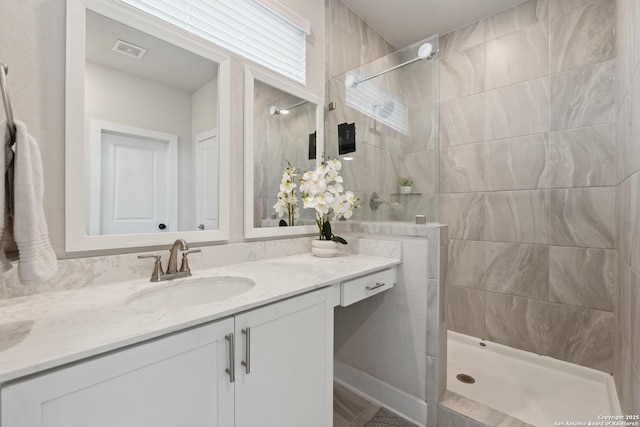 bathroom featuring vanity and tiled shower