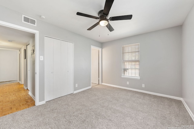 unfurnished bedroom with light colored carpet, ceiling fan, and a closet