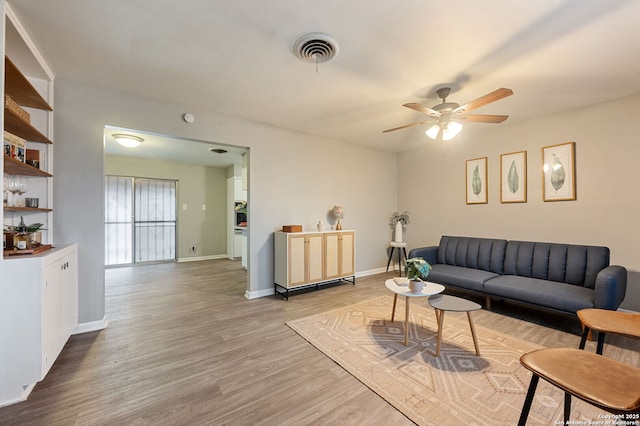 living room featuring wood-type flooring and ceiling fan