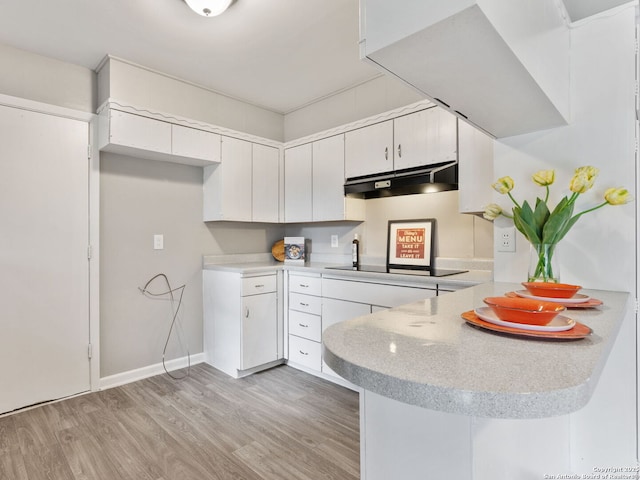 kitchen featuring white cabinetry, black electric stovetop, light hardwood / wood-style floors, and kitchen peninsula