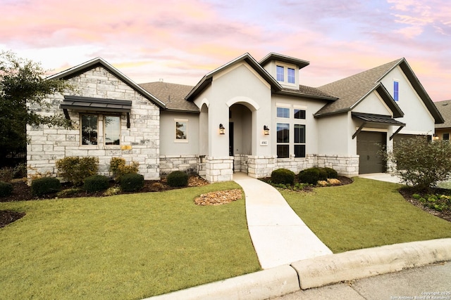 view of front of house featuring a garage and a lawn