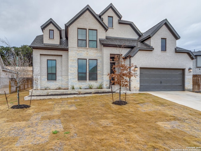 french country home featuring a garage and a front lawn